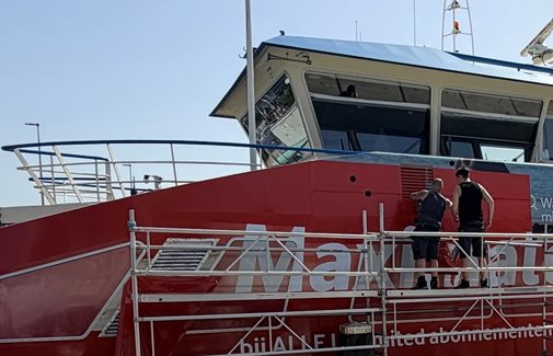 Montage van grafische folie vanaf een werksteiger langs een pont