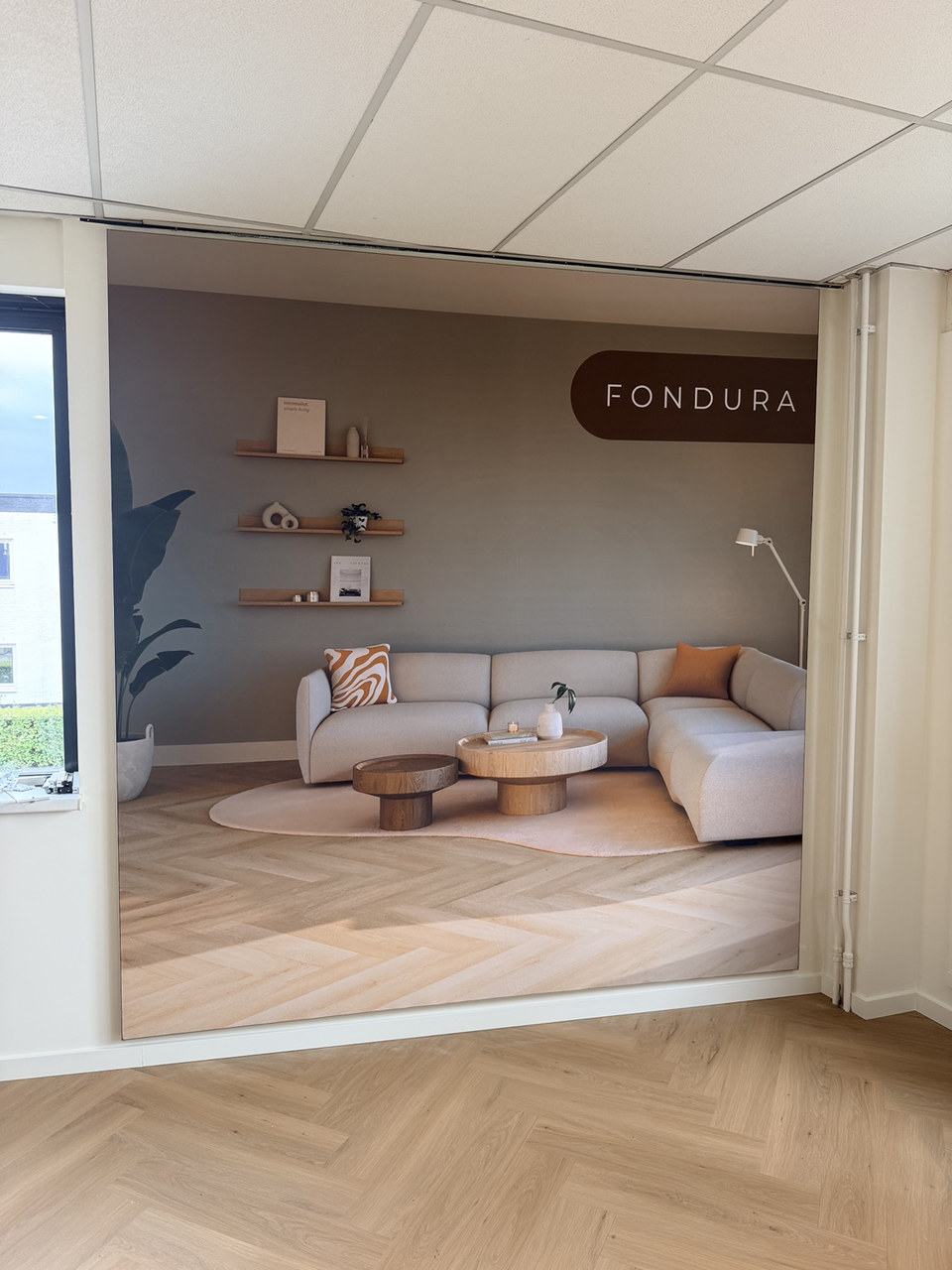 Grootformaat wandvisual met een ingericht interieur als beeld in een wandopening
