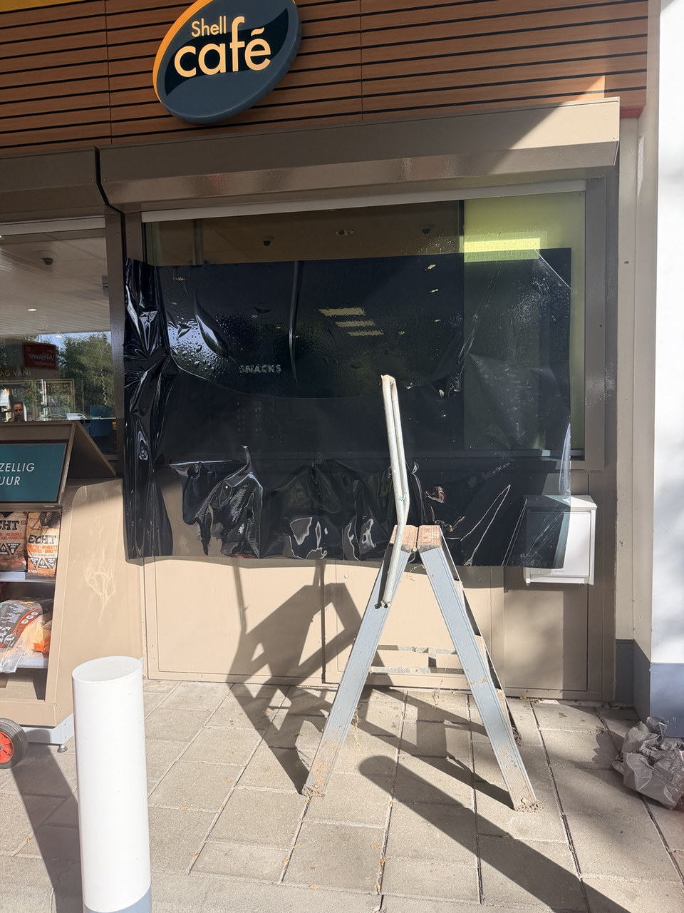 Montage van raamfolie op het raam van een café