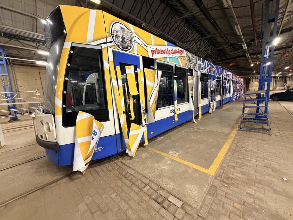Grafische folie op een tram tijdens montage in de werkhal