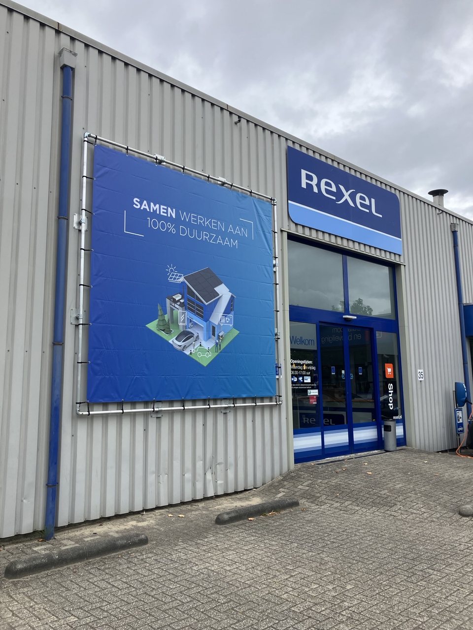 Gevel met Rexel-belettering en een groot grafisch reclamepaneel