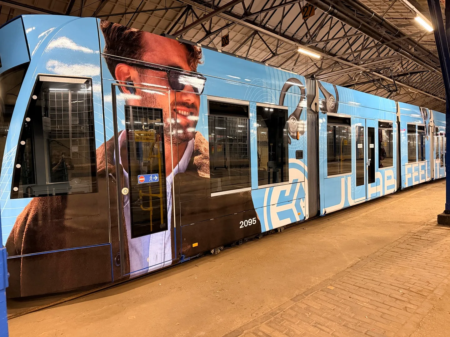 GVB-tram 2095 met blauwe JLab-reclamefolie in de Amsterdamse remise
